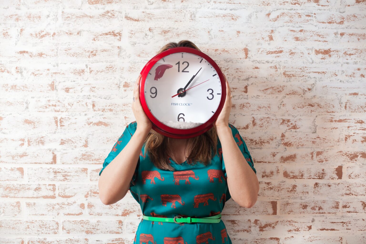 Girl with a clock covering her face as a way of saying save time by using CRM software for planning events