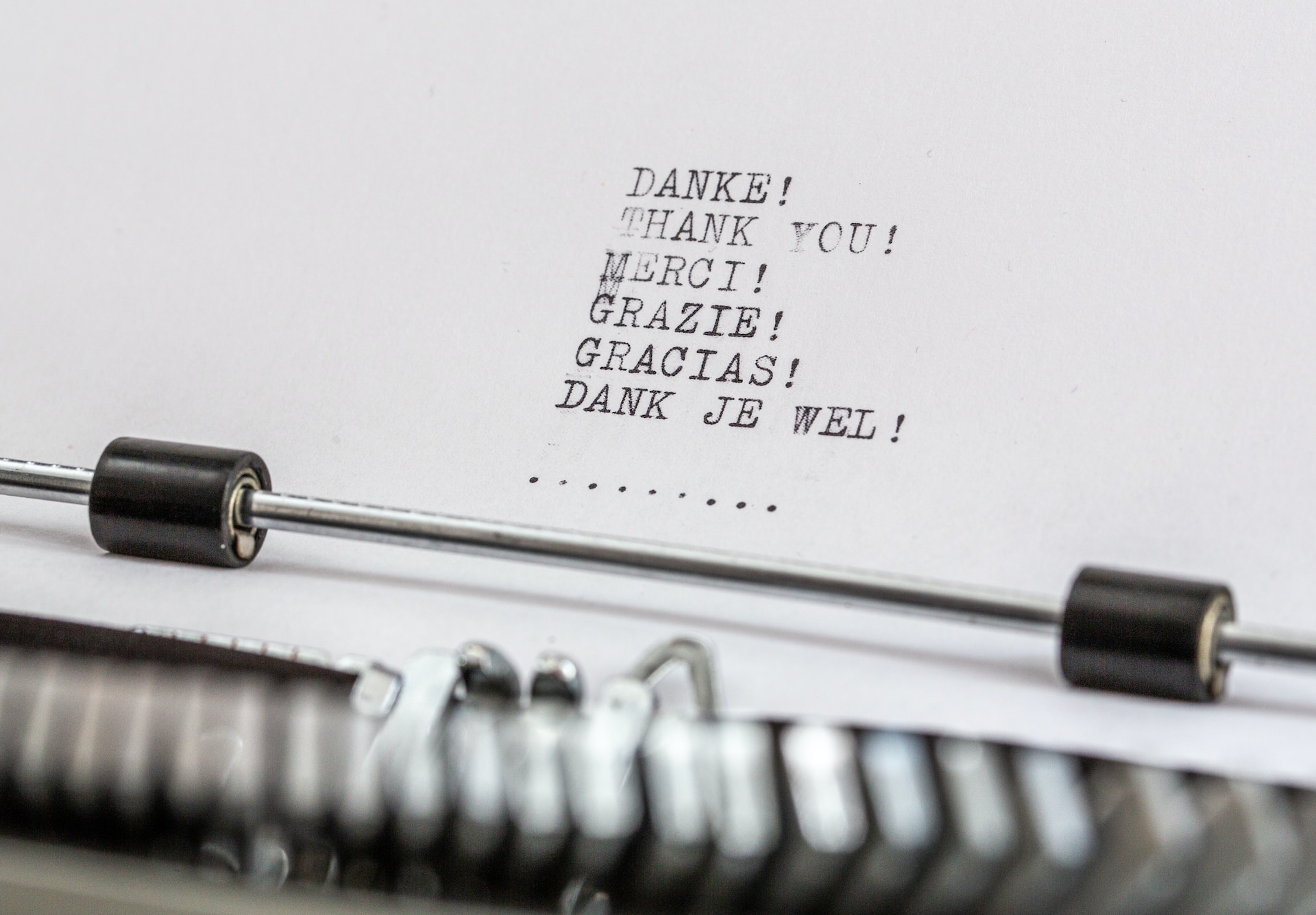A paper with 'thank you' written in different languages on a typewriter.