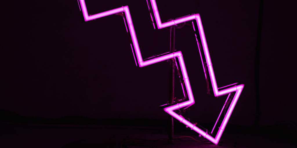 A downward facing neon arrow light