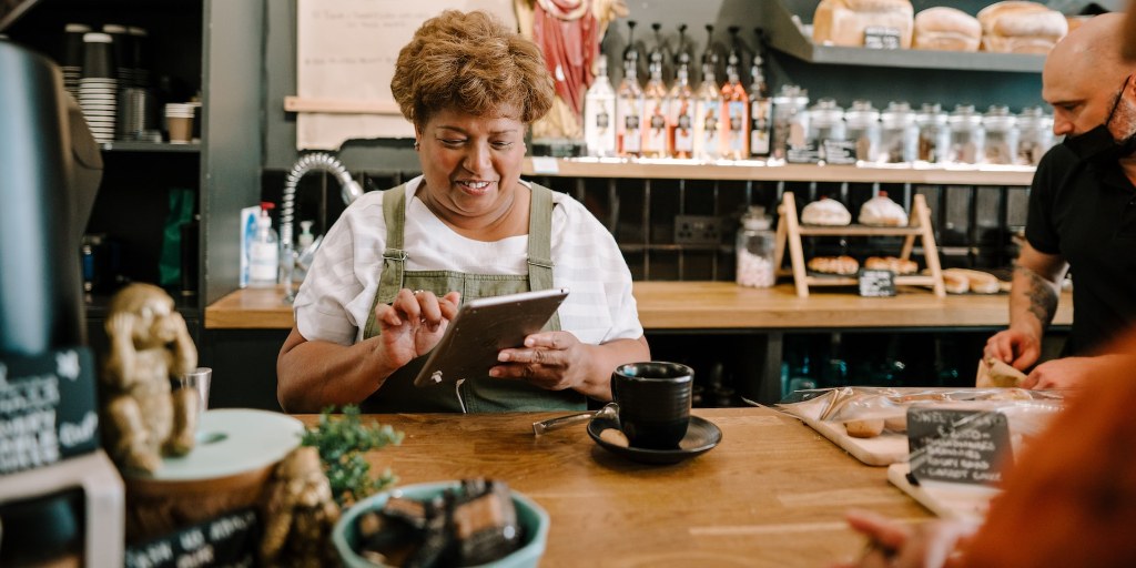 A bakery store owner checking her tablet