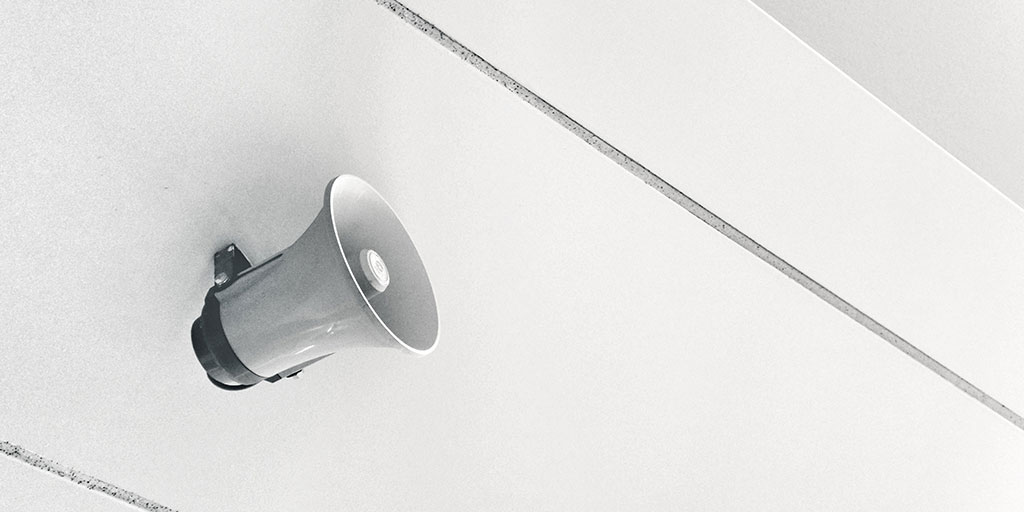 A white megaphone fixed on a white wall