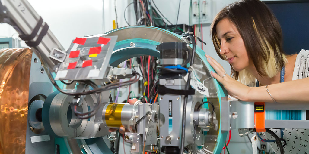 Image of a female scientist adjusting the instrumentation at a laboratory