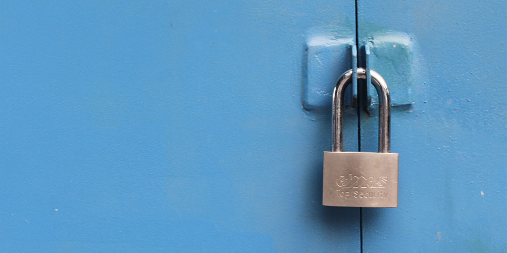 image of a padlock on a blue, wooden door
