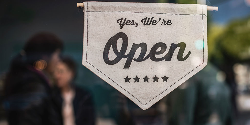 image of a 'we're open' sign in a shop front